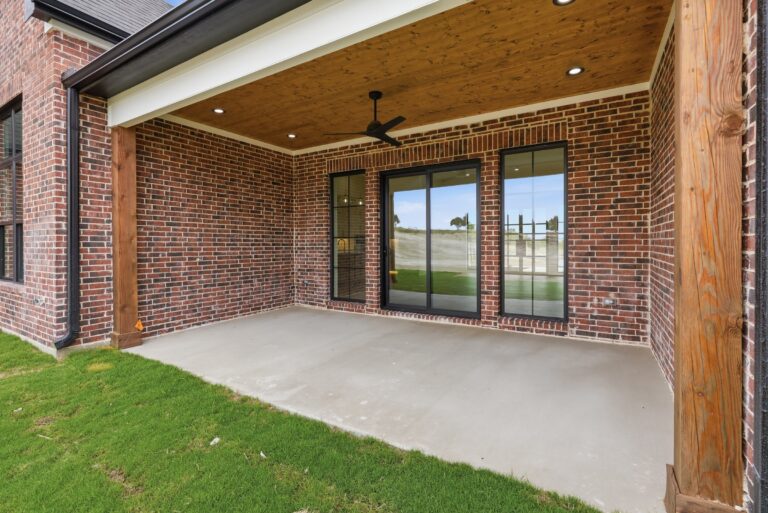 Covered back patio with tongue-and-groove ceiling at 2069 Preserve Trail by M2 Luxury Homes in Timberview Preserve