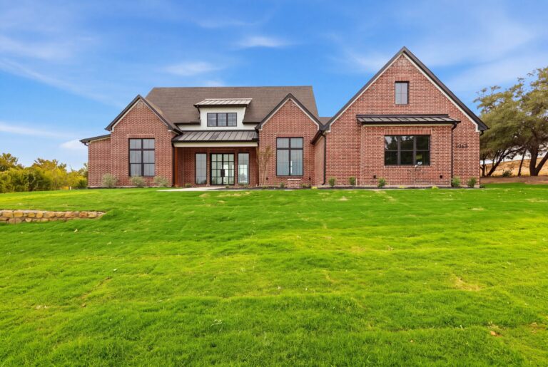 Red brick farmhouse exterior at 2069 Preserve Trail by M2 Luxury Homes in Timberview Preserve