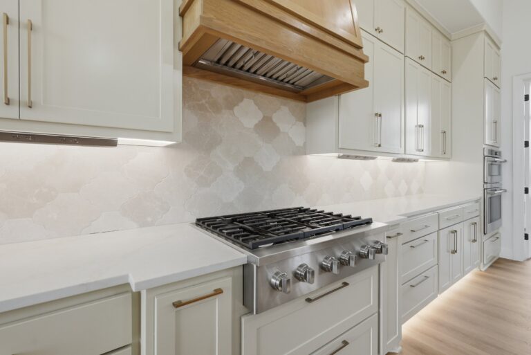 Six-burner gas range with wood range hood at 2069 Preserve Trail by M2 Luxury Homes in Timberview Preserve