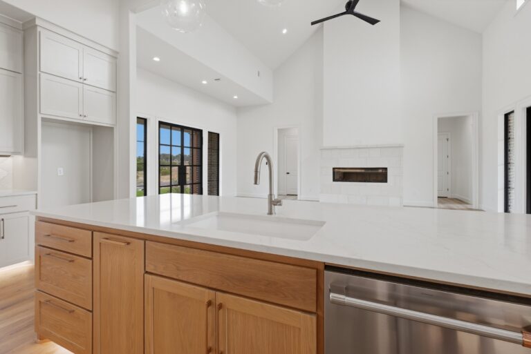 Kitchen with white oak island and white shaker cabinets at 2069 Preserve Trail by M2 Luxury Homes in Timberview Preserve