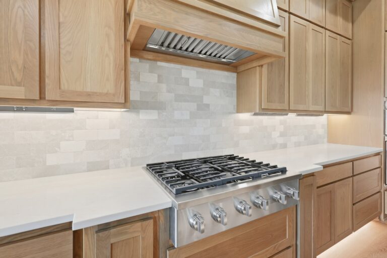 Kitchen with white oak cabinetry and gas range at 2077 Preserve Trail by M2 Luxury Homes in Timberview Preserve